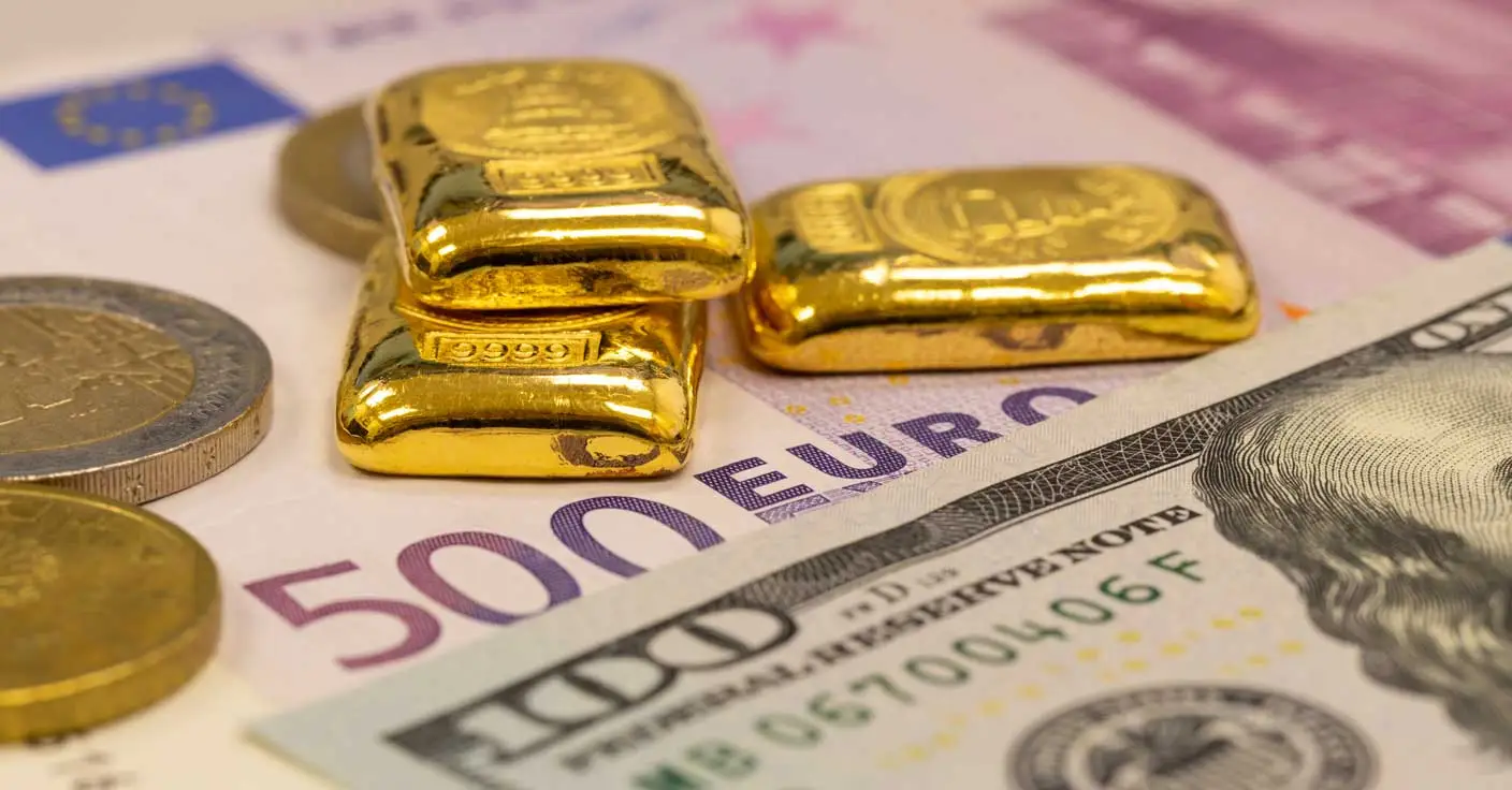 Goldbarren auf Euro- und Dollar-Geldscheine